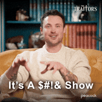 Sponsored gif. Traitors cast member Dylan Efron smiles while saying, “It’s a shit show.” Text also reads, “It’s a shit show,” but the word shit has been replaced by random symbols to hide it.