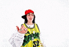 Music Video gif. From Billie Eilish's music video for "LUNCH", Billie is on a stark white background dressed in a white long sleeve shirt and a yellow and black jersey over the top, with a red flat brim hat on. She is pointing at herself while looking into the camera singing her song and getting closer to the lens.
