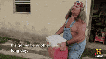 TV gif. An older man from Swamp People with long gray hair, wearing shirtless overalls and an American flag bandanna carries a red cooler out of a house. He speaks to us with a vague frown. Text, "It's gonna be another long day."
