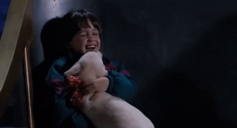 Movie gif. Eric Lloyd as Charlie in "The Santa Clause" laughs with pure joy while a puppy climbs up him to lick his face.