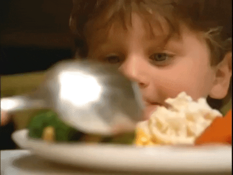 Ad gif. Boy stares at his plate of broccoli set on his Thanksgiving plate, licking his lips.