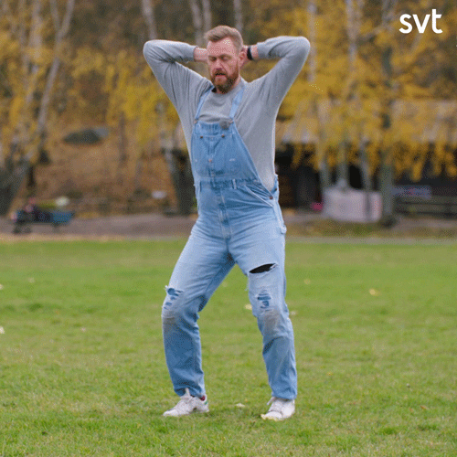 Celebrity gif. Kristoffer Appelqvist, a Swedish comedian, is wearing overalls and has his hands on the back of his head while he stiffly shakes his hips from side to side.