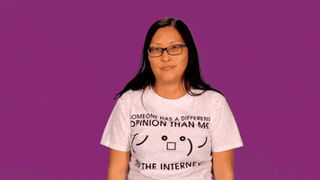 Video gif. Woman wearing a shirt that says, “Someone has a different opinion of me on the internet,” shrugs her shoulder as if to say, “Whatever.”