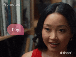 Sponsored gif. A woman in a bookstore talks to someone out of frame, looking nervous and interested. A speech bubble next to her reads "hey," as three drawn animated arrows spiral out of it pointing to text that reads, "screaming," "crying," and "throwing up." The Tinder logo is in the bottom right corner.