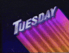 Text gif. Metallic purple title reading, "Tuesday" sits slanted while gradient magenta to orange streaks add colorful dimensionality to the text. Flashing bars going from light pink to purple pass through to further illuminate the word. The backdrop shows mini comets flying against a night sky.