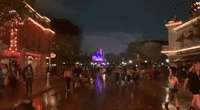 Visitors Hurry Down Disneyland's Main Street During Heavy Downpour