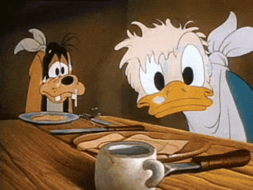 Disney gif. Desperately hungry, Donald Duck and Pluto lean over a table in front of empty plates, sweating profusely.