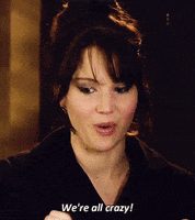 Celebrity gif. Jennifer Lawrence smiles and shakes slightly while she looks at us with wide eyes, saying, "We're all crazy!"