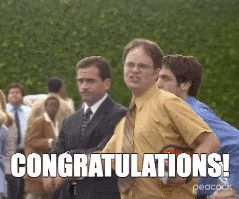 The Office gif. Rainn Wilson as Dwight Schrute jumps up and fist pumps the air in pure excitement as if the best thing in his life has just happened. People stand behind him, not joining him in that same excitement. Text reads: “Congratulations!”