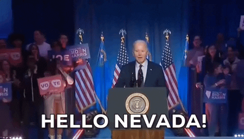 Political gif. Joe Biden stands at a podium in front of American flags and a crowd of supporters holding signs that read, "Biden Harris" and "Vote!" He says, “Hello Nevada!”