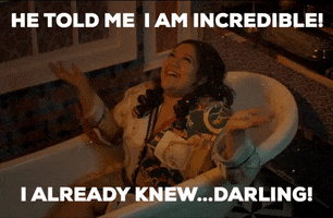 Music video gif. From the video for Kinni Kinni Vaari, Tanvi Geetha Ravishankar lies in a bathtub and spreads her robed arms out, looking up joyfully, while gold flakes appear to fall down all over her. Text, "He told me I am incredible! I already knew...darling!"