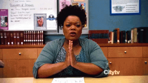 TV gif. Yvette Nicole Brown as Shirley in Community presses her hands together in prayer at a table, mouthing something with furrowed brows.