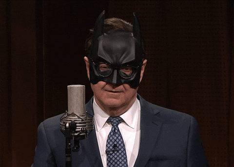 The Tonight Show gif. Steve Higgins wears a kid’s batman mask with his glasses over top and stares at us with squinted, serious eyes as he says, “I’m batman!”
