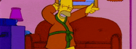 Simpsons gif. Homer is dancing in his robe and he does dual finger guns, pointing left and right and back again.