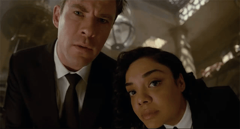 Movie gif. Tessa Thompson as Molly and Chris Hemsworth as Agent H in Men in Black International lean overhead and stare at us like we're a weird little bug. They squint their eyes in confusion. 