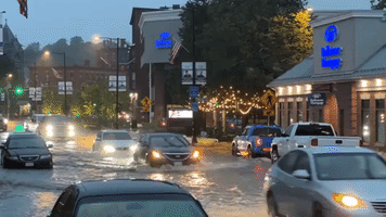 Vehicles Make Their Way Along Flooded Massachusetts Street