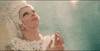 Music video gif. In the video for G.U.Y., dressed in a white floral headdress and dress, Lady Gaga looks hopefully heavenward and clasps her hands together.