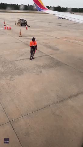 Airport Worker Dances on Tarmac as Plane Readies for Takeoff