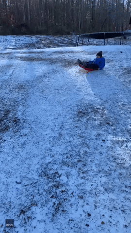 Kid on Sled Does Disappearing Act Under Truck