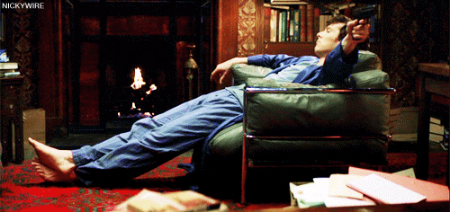 TV gif. Benedict Cumberbatch as Sherlock Holmes in Sherlock sits slouched in a chair, dressed in his pajamas. He sits listlessly and shoots a gun to his left without looking. Text, “Bored.”