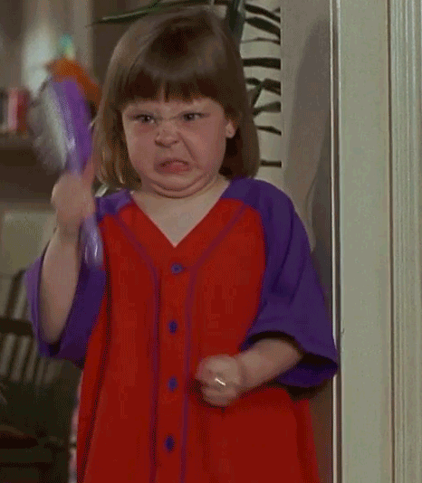Video gif. Young girl with a contorted and angry face waves a purple airbrush, fiercely shaking her head with gritted teeth.