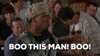 Movie gif. A scene from the movie Half Baked. A man stands with a disgruntled looking crowd sitting behind him. He points angrily as if offended at someone, saying., “Boo this man! Boo!” He then grabs the hat off of his head and chucks it. The crowd behind him starts to get up and follow his protest.