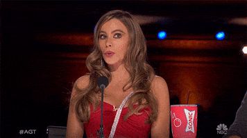 Reality TV gif. Actress Sofia Vergara makes a surprised face and covers her mouth in an "oh no!" gesture in her judge's seat on America's Got Talent.