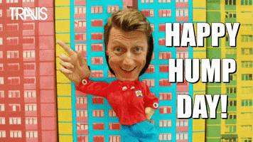 Celebrity gif. Dougie Payne from The Travis Band has his head and hand stuck in a cardboard cut out. A cardboard body dances from side to side and his hand points downwards in rhythm to his body. Text, "Happy hump day!"