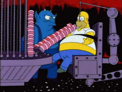 The Simpsons gif. Bloated Homer sits strapped to a machine as it feeds him donuts four at a time while Blue Demon looks on.