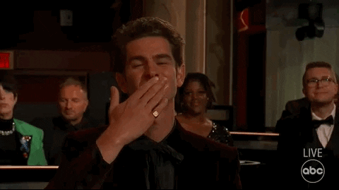 Celebrity gif. From the audience, Andrew Garfield applauds and blows kisses at The Academy Awards.