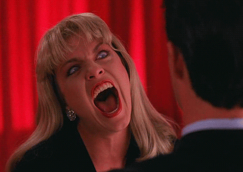TV gif. Sheryl Lee as Laura Palmer on Twin Peaks eyes are wide and her teeth are bared, screaming demonically at the top of her lungs.