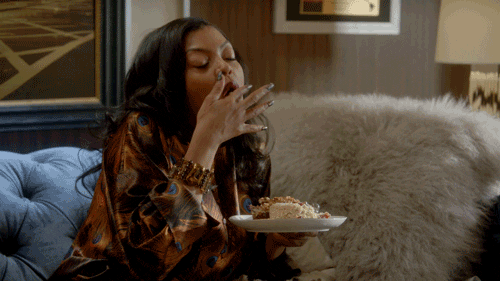 TV gif. Taraji P. Henson as Cookie on Empire enjoys a plate of food, licking her fingertips.