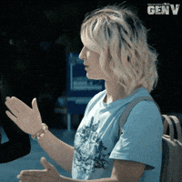 Sponsored gif. Emma Meyer from the Amazon Prime show Gen V claps her hands together once and then points at unseen people before walking off. Text reads, “Enjoy.”