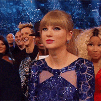 Celebrity gif. In the audience at an awards show, a dolled-up Taylor Swift nods and shrugs her shoulders in agreement.