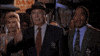 Movie gif. In a clip from The Naked Gun, three characters slap their own foreheads in astonishment. We then see a group of men in a video editing bay, then an entire audience slapping their foreheads, all in the same manner.