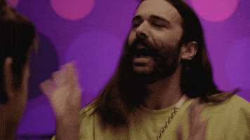 Reality TV gif. Jonathan Van Ness on Queer Eye shakes his hands around with his long luscious hair flying behind him. He screams in excitement like he’s just heard the best news ever.