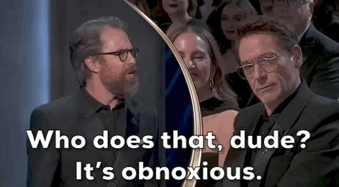 Oscars 2024 GIF. Split screen of Sam Rockwell saying to Robert Downey Junior, with much attitude, “Who does that dude? It’s obnoxious.”