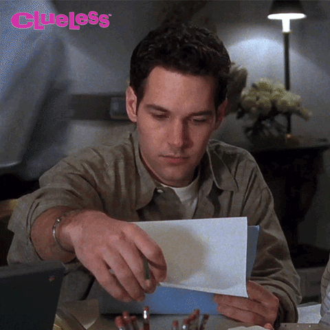 Movie gif. Annoyed by the interruption, Paul Rudd as Josh in Clueless looks up from reading a document.