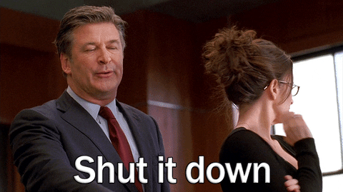 TV gif. Alec Baldwin as Jack Donaghy in 30 Rock looking exasperated and saying, "shut it down," as Liz Lemon, played by Tina Fey, appears uncomfortable.
