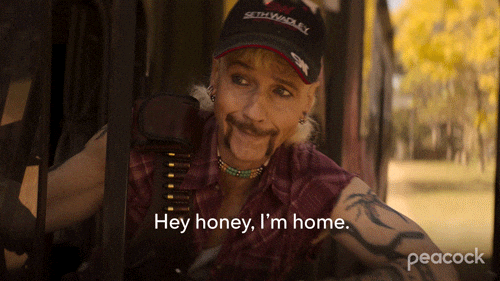 DESCRIÇÃO DA IMAGEM: Homem de colete vermelho e boné preto para o carro enquanto diz "Hey honey, I'm home"