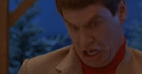 Movie gif. Jim Carey as Lloyd in "Dumb and Dumber" makes an absurd retching facial expression and gesture, bucking his neck forward and curling his lips over his teeth and then clenching his jaw.
