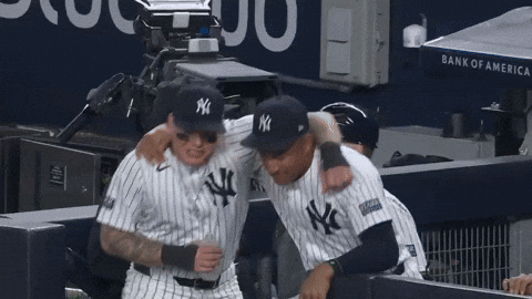 Sports gif. Alex Verdugo and Jahmai Jones of the New York Yankees, dance and shimmy together in the dugout, arms around each other, in a display of friendship.