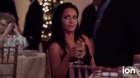 TV gif. Tristin Mays as Riley in MacGyver. She's holding a wine glass at a table and she looks at someone in disbelief before shaking her head and dismissing them.