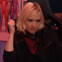 Video gif. Youtuber Emma Fyffe reacts with a smirk, then a laugh and a big smile.