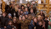 Movie gif. Will Ferrell as Buddy in Elf jumps up and down, clapping his hands in excitement. Behind him are a group of young children also jumping up and down cheering with excitement like he is. Parents stand behind the children smiling.