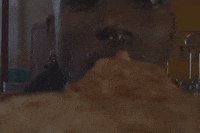 Music video gif. From the perspective of the pizza slice, a man's mouth chomps the pizza slice in SZA's music video, "Drew Barrymore."