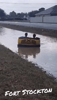 Calm After the Thunderstorm: Texas Brothers Glide Along Flooded Ditch in Inflatable Couch
