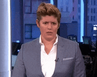 Celebrity gif. Sally Kohn sits behind a news desk, shakes her head, then drops her face onto her palm.