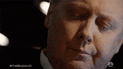 TV gif. James Spader as Red on the Blacklist. He's looking down but slowly flicks his eyes up as he judges, staring us down with a look of anger and disapproval on his face.
