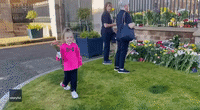 Little Girl Lays Flowers as Tribute to Queen Elizabeth II at Hillsborough Castle